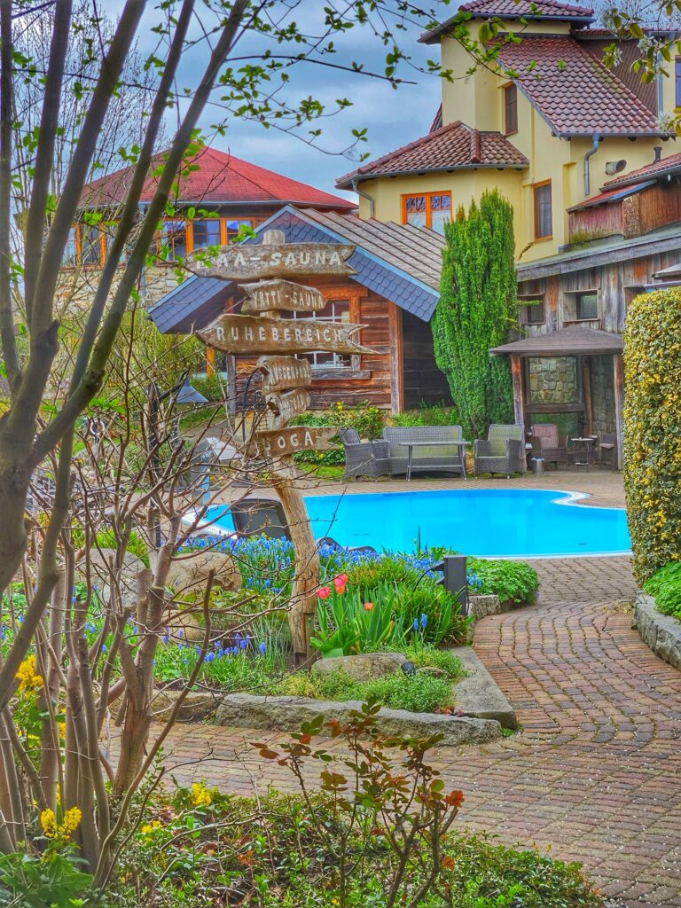 Außenpool des Wellnesshotels Seeschlößchen mit Blick auf das Hotel – Babymoon Senftenberg