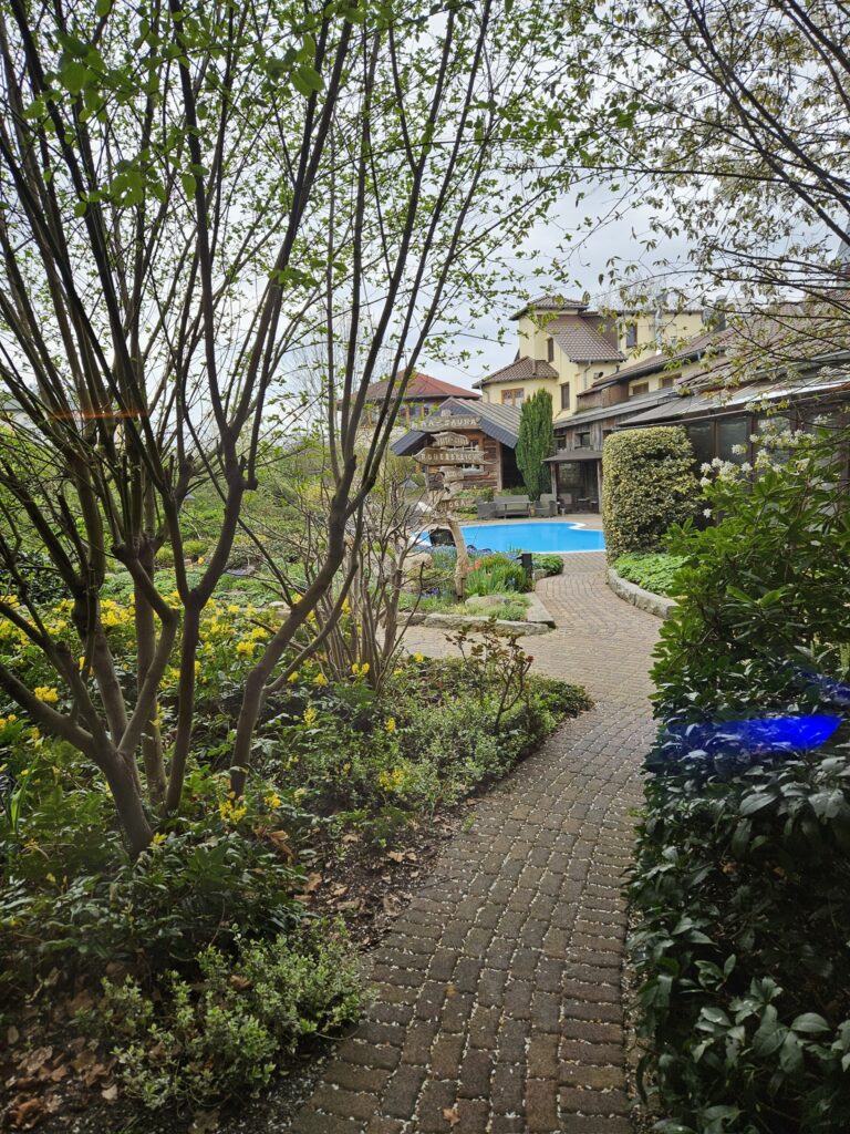 Außenbereich des Wellnessbereichs mit Holzsteg zum Pool – Babymoon Senftenberg